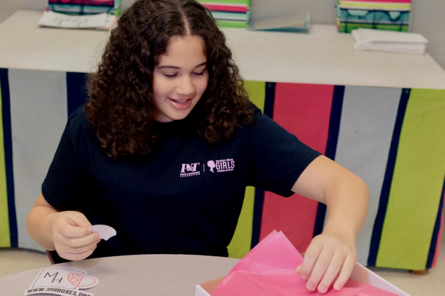 Mila fills boxes with fidget toys and other items to help girls with mental health