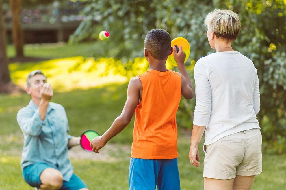 Fit for the Whole Family Parents playing an outdoor ball game with child